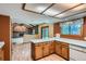 Cozy kitchen featuring oak cabinets, white countertops, wood floors, and view to the living area at 20596 E Shefield Ct, Parker, CO 80138