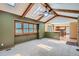 Open living room showing wood beams, skylights, large windows and an adjacent kitchen at 20596 E Shefield Ct, Parker, CO 80138