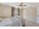 This neutral bedroom offers soft carpet and a ceiling fan above the made bed with light pouring in through the window at 7605 Shenandoah Dr, Elizabeth, CO 80107