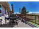 The sunny deck has comfortable outdoor seating with a table, chairs, umbrellas, and a green yard at 7605 Shenandoah Dr, Elizabeth, CO 80107