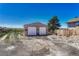 Detached two-car garage featuring two roll up doors and ample parking space on a gravel driveway, on a sunny day at 7605 Shenandoah Dr, Elizabeth, CO 80107