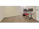 This neutral carpeted office is ready for work, with a desk, computer, printer, and red chair at 7605 Shenandoah Dr, Elizabeth, CO 80107