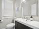 A well-lit bathroom featuring a modern vanity, toilet, and window with blinds at 142 N Logan St, Denver, CO 80203