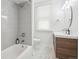 Bright bathroom featuring a tub and shower combo, vanity with wood cabinets, and hexagon tiled floor at 142 N Logan St, Denver, CO 80203