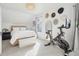 A bright bedroom with an exercise bike, decorative hats, a large mirror, and a bed at 142 N Logan St, Denver, CO 80203