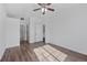 Bright bedroom with light wood floors, a ceiling fan, and a view into the hallway at 5255 Memphis St # 1112, Denver, CO 80239