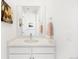 This bright bathroom features white cabinets, light countertop, a single sink and large mirror at 455 Rogers Way, Castle Rock, CO 80104