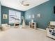 This playroom/bedroom is spacious and features neutral carpet, a window, play kitchen, tent, and soft armchair at 455 Rogers Way, Castle Rock, CO 80104