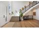 Bright foyer with modern staircase, light wood floors, and tall windows, creating an inviting and spacious entrance at 455 Rogers Way, Castle Rock, CO 80104