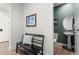 Inviting hallway with stylish bench seating and a glimpse of the elegant powder room's pedestal sink at 455 Rogers Way, Castle Rock, CO 80104