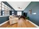 Spacious living room includes light hardwood floors, a leather sectional, a ceiling fan and large pane windows at 455 Rogers Way, Castle Rock, CO 80104