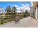 A wooden back deck with an ornamental railing overlooks the lush landscaping at 7220 Spring Creek Cir, Niwot, CO 80503