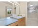 Bathroom featuring vanity with sink, large mirror, and shower, plus ample counter space at 7220 Spring Creek Cir, Niwot, CO 80503