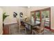 Dining area with a rustic table, wood floors, and large windows offering natural light at 7220 Spring Creek Cir, Niwot, CO 80503