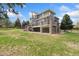 Multi-story home with a large deck featuring stone pillars and a spacious yard, perfect for outdoor enjoyment and entertaining at 7220 Spring Creek Cir, Niwot, CO 80503