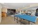 Open game room featuring a ping pong table, pool table, fireplace, TV, and wet bar at 7220 Spring Creek Cir, Niwot, CO 80503