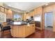 Bright kitchen featuring an island, stainless steel refrigerator, wooden cabinets, and hardwood floors at 7220 Spring Creek Cir, Niwot, CO 80503