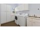 Functional laundry room with ample cabinet storage, sink, washer, and dryer at 7220 Spring Creek Cir, Niwot, CO 80503