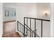 Hallway with wrought iron railing leading to living area with ample light at 2297 S Oswego Way, Aurora, CO 80014
