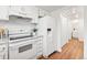 Clean, white kitchen featuring modern appliances and convenient layout, leading to bathroom at 2297 S Oswego Way, Aurora, CO 80014