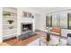Comfortable living room with fireplace and built-in shelves, illuminated by a large window at 2297 S Oswego Way, Aurora, CO 80014