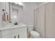 Bright bathroom with a white vanity, toilet, and shower with a gray striped curtain at 4612 S Wenatchee St # A, Aurora, CO 80015