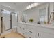 Bright bathroom with dual sinks, modern fixtures, glass shower, and large mirror at 4612 S Wenatchee St # A, Aurora, CO 80015