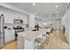 Bright, modern kitchen with stainless steel appliances, a large island, and bar seating that opens to the living area at 4612 S Wenatchee St # A, Aurora, CO 80015