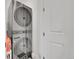 Laundry room with a modern, stacked washer and dryer unit next to a closed door at 4612 S Wenatchee St # A, Aurora, CO 80015