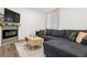Charming living room featuring a cozy fireplace, modern sofa, and ample natural light with wood flooring at 4463 Steele St, Denver, CO 80216