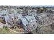View of townhomes featuring grey roofs, brick chimneys, small patio areas, and mature trees at 8300 W 87Th Dr # B, Arvada, CO 80005
