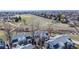 View of townhomes near an open green space with walking trails and distant city views at 8300 W 87Th Dr # B, Arvada, CO 80005
