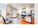 Modern kitchen with white cabinets, stainless steel appliances, breakfast bar, and hardwood floors, perfect for cooking at 8300 W 87Th Dr # B, Arvada, CO 80005