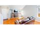 Bright living room featuring hardwood floors, a brick fireplace, and large windows, creating a welcoming space at 8300 W 87Th Dr # B, Arvada, CO 80005