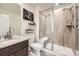Modern bathroom featuring walk-in shower with glass door, wood-look tile, granite vanity, and sleek fixtures at 1063 Sandstone Cir, Erie, CO 80516