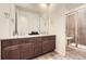 Bathroom featuring double sink vanity, granite countertops, and a glass-enclosed shower at 1063 Sandstone Cir, Erie, CO 80516