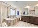 Bright bathroom featuring double sinks, granite counters, soaking tub and separate shower at 1063 Sandstone Cir, Erie, CO 80516