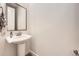 Clean powder room with a pedestal sink, framed mirror, and tiled flooring at 1063 Sandstone Cir, Erie, CO 80516