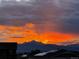 Sunset over neighborhood, featuring silhouetted mountain view at 1063 Sandstone Cir, Erie, CO 80516
