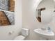 Modern half bathroom with a pedestal sink, toilet, and decorative art at 3347 Belleville Ridge Rd, Elizabeth, CO 80107