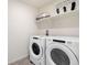 Functional laundry room equipped with a modern washer and dryer, and shelving for storage at 3347 Belleville Ridge Rd, Elizabeth, CO 80107