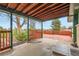 Backyard covered patio looking out onto the wooden deck and grass lawn at 13621 E Center Ave, Aurora, CO 80012