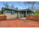 Backyard featuring a wooden deck, brick and siding exterior, and some landscaping at 13621 E Center Ave, Aurora, CO 80012