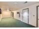 Basement featuring green carpet, lighting, and access to storage at 13621 E Center Ave, Aurora, CO 80012