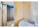 Bathroom featuring a sink, toilet, and tiled shower stall at 13621 E Center Ave, Aurora, CO 80012