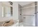Updated bathroom with modern gray tile, grab bars, and a shower, providing convenience and accessibility at 13621 E Center Ave, Aurora, CO 80012
