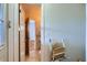 Hallway view of bathroom with accessibility chair and tiled floors, offering convenience and safety at 13621 E Center Ave, Aurora, CO 80012