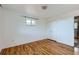 Bedroom featuring hardwood floors, a closet, and natural light from the window, creating a cozy retreat at 13621 E Center Ave, Aurora, CO 80012