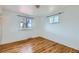 Bedroom with hardwood floors and natural light from two windows, creating a bright and welcoming space at 13621 E Center Ave, Aurora, CO 80012