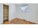 Bedroom featuring hardwood floors, a closet, and natural light from the window, creating a cozy retreat at 13621 E Center Ave, Aurora, CO 80012